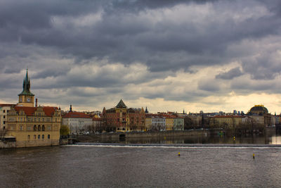 Buildings in city against cloudy sky