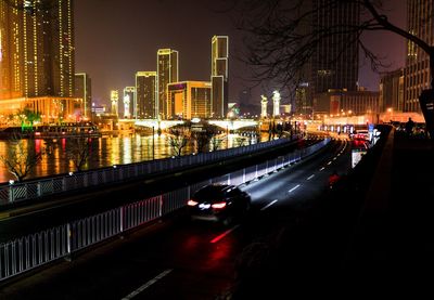 Cars on street amidst buildings in city at night