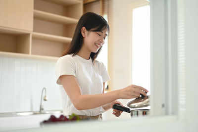 Young woman using mobile phone at home