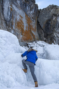 Rear view of person standing on snow covered mountain