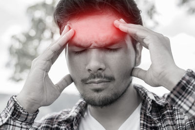 Man with headache against sky