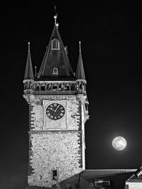 Low angle view of clock tower against sky at night