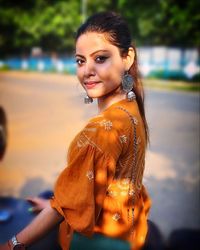 Portrait of smiling young woman standing outdoors