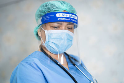 Close-up of doctor wearing mask standing in hospital