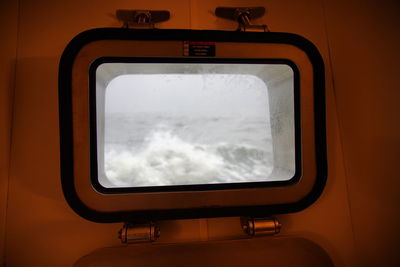 Reflection of clouds in sky seen through train window