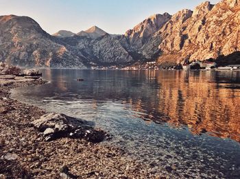Scenic view of lake by mountains against sky