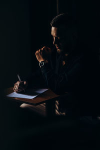 Young man working in dark