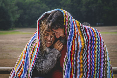 Happy couple enjoying under blanket