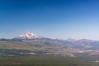 Scenic view of snowcapped mountain against blue sky