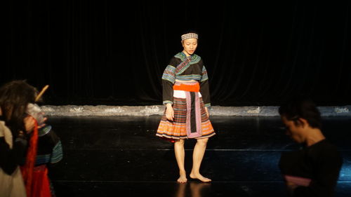 Rear view of woman standing against wall