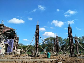 Low angle view of metallic structure on field against sky