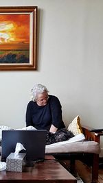 Portrait of woman sitting on table at home