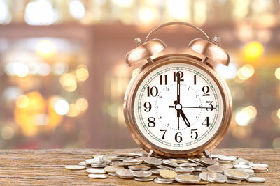Close-up of alarm clock and coins on table