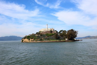 Island amid calm sea against the sky