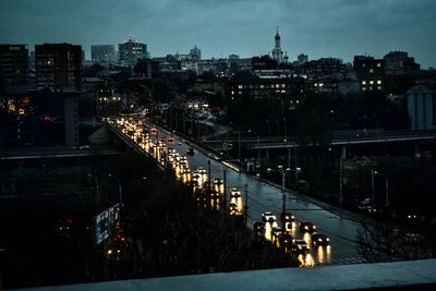 Illuminated bridge and cityscape against sky at dusk