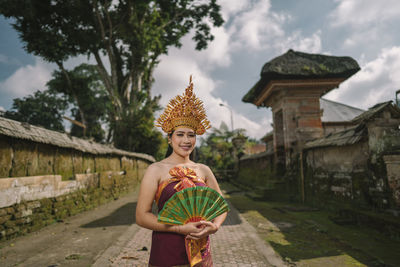 Portrait of young woman wearing traditional clothing standing on land