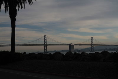 View of suspension bridge against cloudy sky