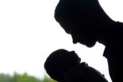 Portrait of silhouette father with son against sky