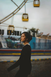 Side view of woman standing against train