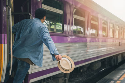 Rear view of man standing in train