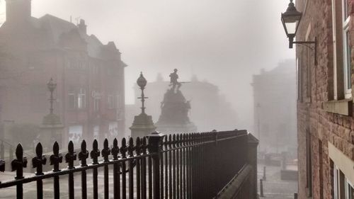 Buildings in city during foggy weather