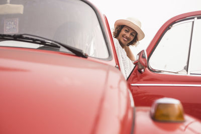 Woman standing by friend sitting in car