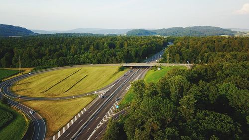 High angle view of road amidst trees against sky