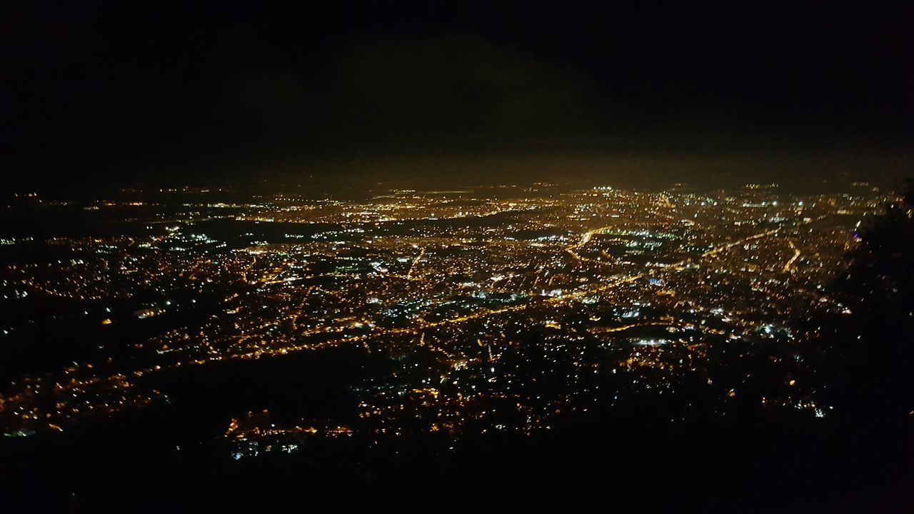 AERIAL VIEW OF ILLUMINATED CITY AT NIGHT