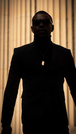 Portrait of young man standing against wall