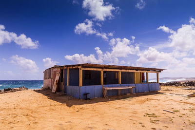 Lifeguard hut on beach against sky