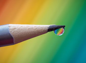 Close-up of colored pencils with drop of colors falling 