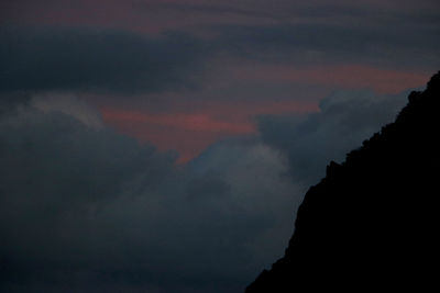 Low angle view of silhouette mountain against sky at sunset