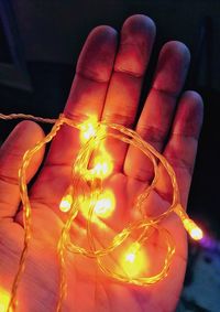 Close-up of hand holding illuminated lighting equipment