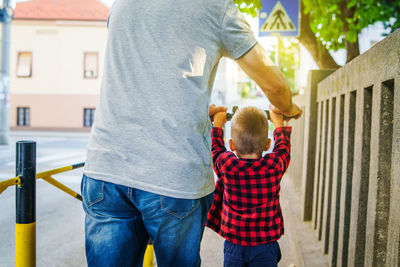 Rear view of father and son on footpath