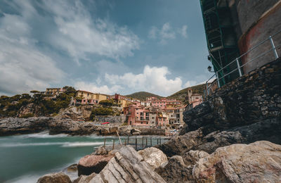 Buildings by rocks against sky