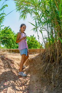 Full length portrait of woman standing on land against sky