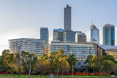 Trees and buildings against sky in city