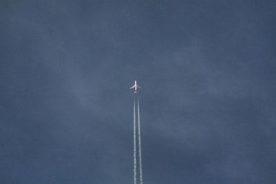 Low angle view of airplane flying against sky