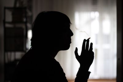 Side view of a silhouette man smoking