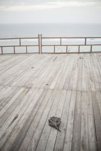 Wooden pier over sea against sky