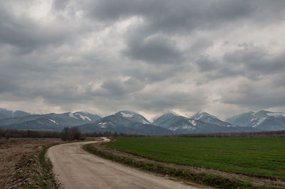 Scenic view of landscape against storm clouds