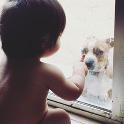 Rear view of shirtless man with dog