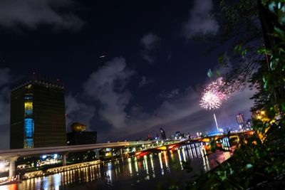 View of firework display over river at night