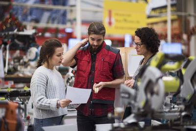 Salesman discussing with female customers in hardware store