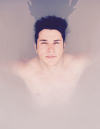 High angle portrait of handsome young man in swimming pool