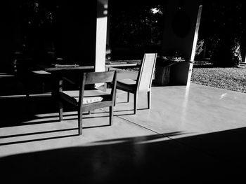 Empty chairs and table against trees