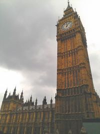 Low angle view of clock tower against cloudy sky