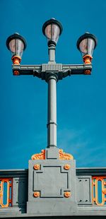 Low angle view of street light against building against sky