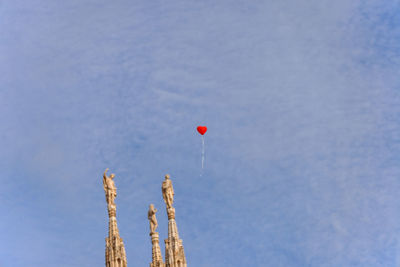 Low angle view of balloons against blue sky