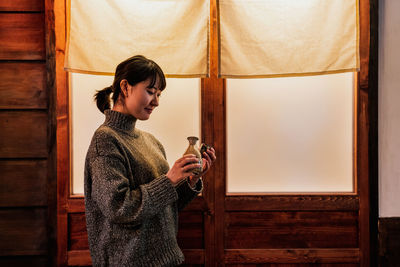 Side view of woman holding camera